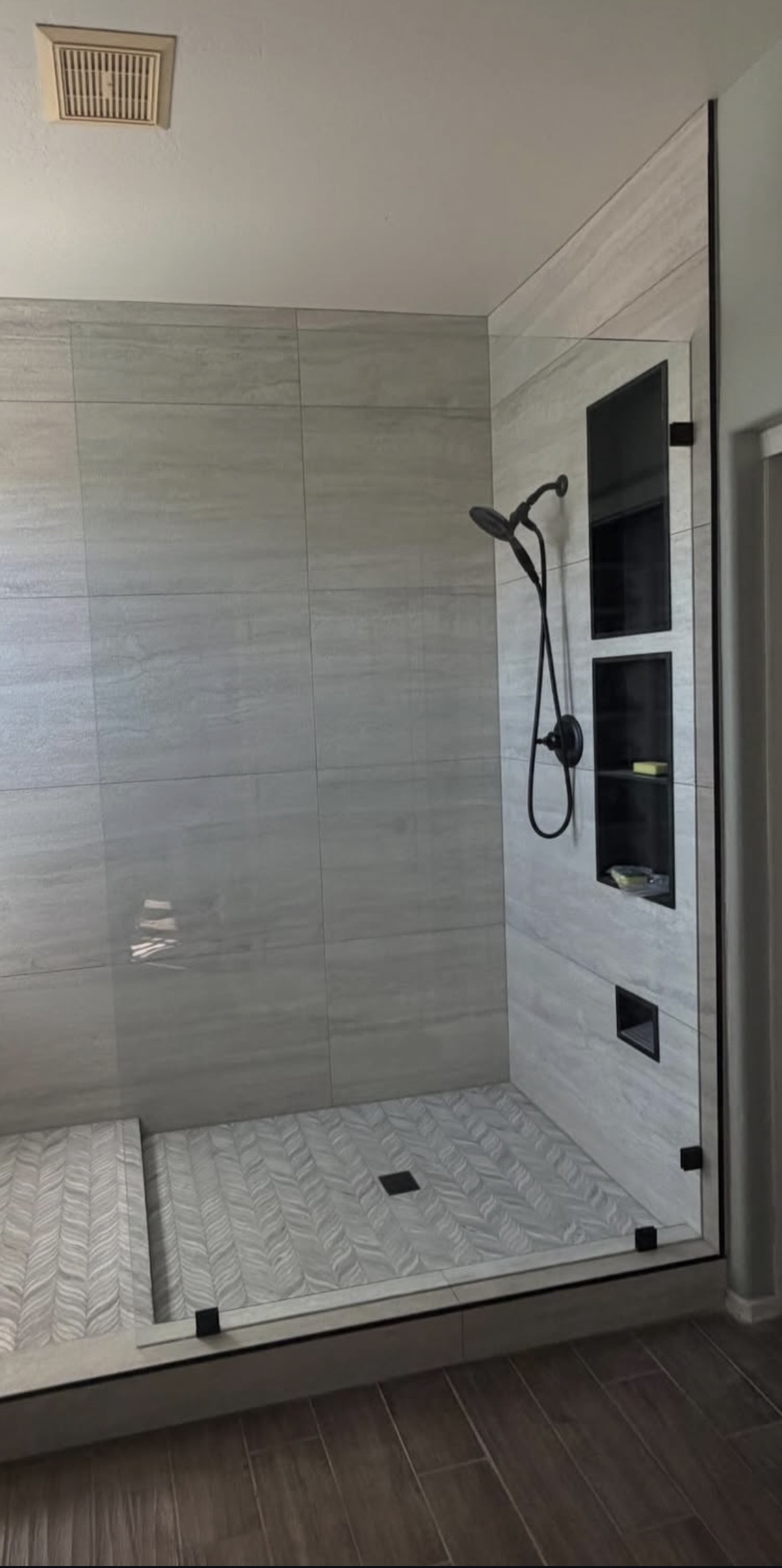 Frameless glass shower with matte black hardware
